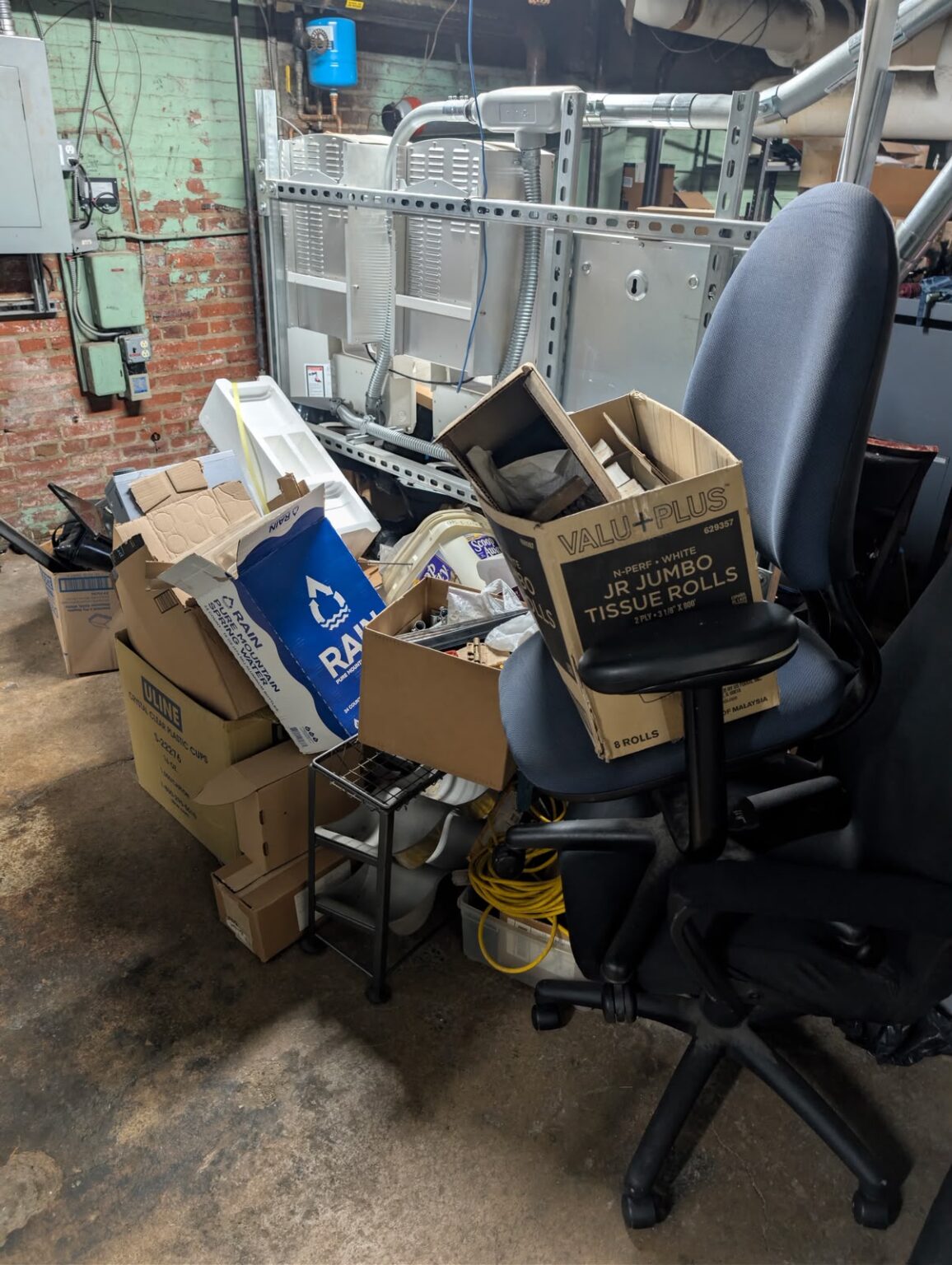 Boxes, office chairs and bulky items prepared for a basement cleanout by Dumpire LLC