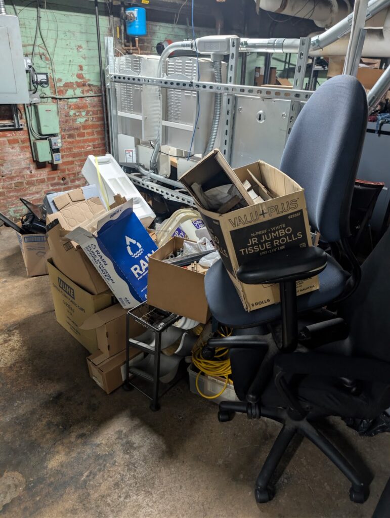 Boxes, office chairs and bulky items prepared for a basement cleanout by Dumpire LLC