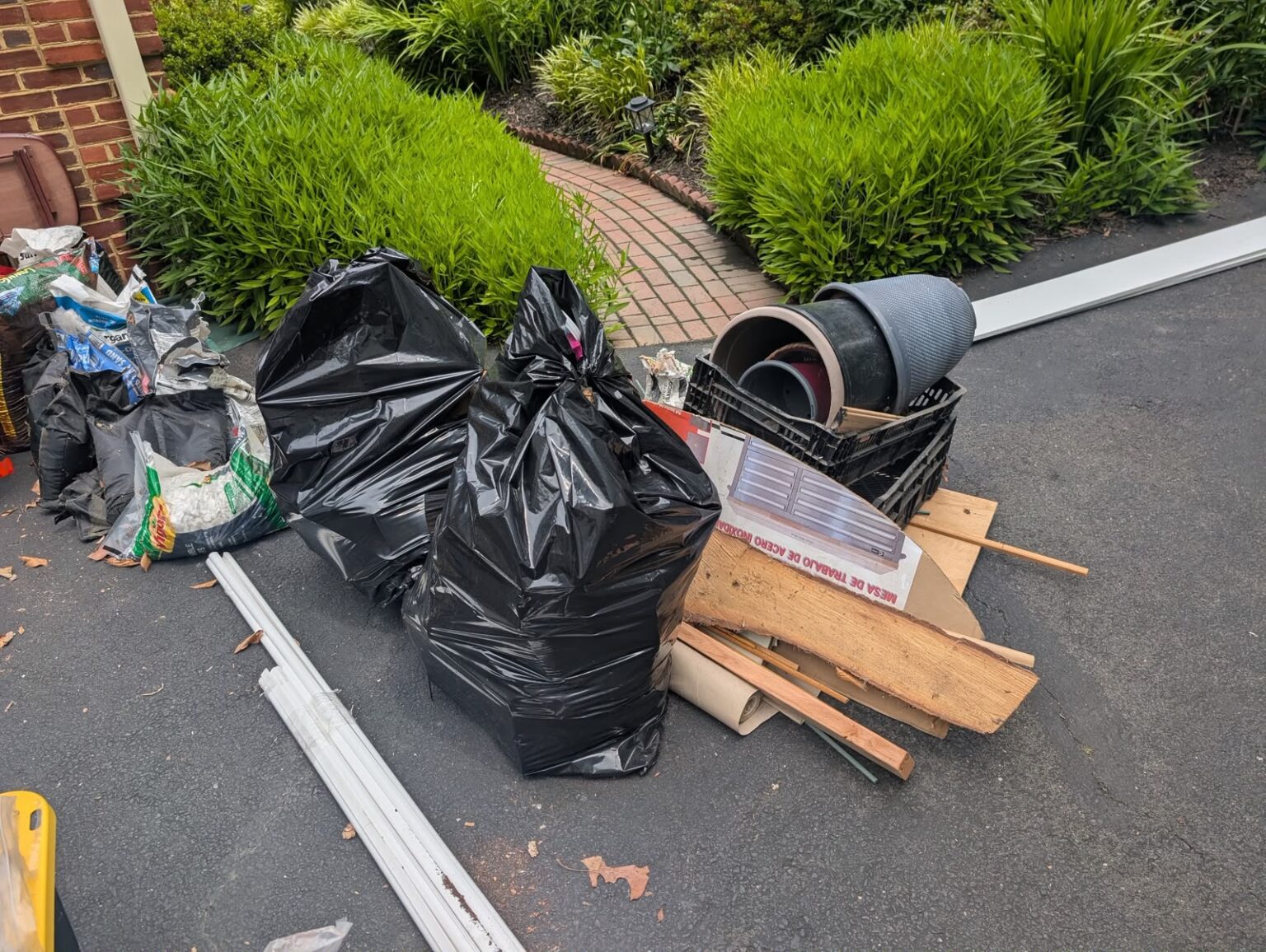 Bagged waste, planters and wood debris prepared for removal by Dumpire LLC